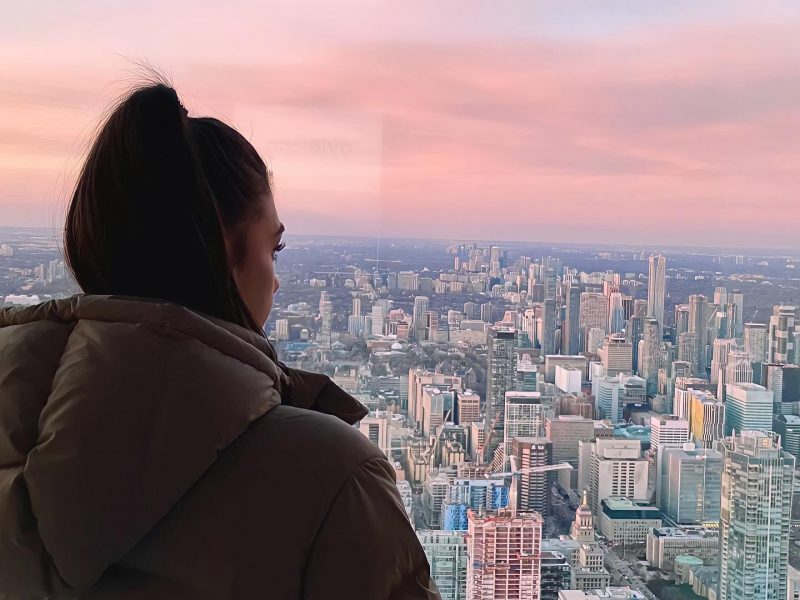 fille de dos qui regarde la vue de Toronto avec un coucher de soleil rose