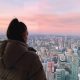 fille de dos qui regarde la vue de Toronto avec un coucher de soleil rose